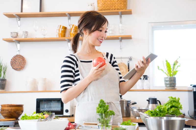 キッチンで料理を作る若い主婦